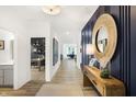 Spacious hallway with wood-look floors, blue accent wall and views into adjacent rooms at 8684 Marietta Ln, McCordsville, IN 46055