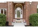 Covered front porch with decorative pots and a large arched doorway with glass paneled door at 8723 Bergeson Dr, Indianapolis, IN 46278