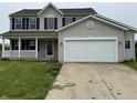 Charming two-story home with a covered porch, black shutters, and an attached two-car garage at 8939 Newchurch Blvd, Indianapolis, IN 46231