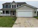 Charming two-story home with a covered porch, black shutters, and an attached two-car garage at 8939 Newchurch Blvd, Indianapolis, IN 46231