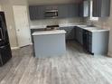 Modern kitchen with grey cabinets, stainless steel appliances, white countertops, and a large island at 8939 Newchurch Blvd, Indianapolis, IN 46231
