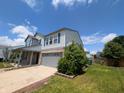 Charming two-story home featuring a two-car garage, a sunny day, and landscaping at 9206 Huntleigh Cir, Plainfield, IN 46168