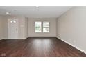 Open living area with dark hardwood flooring and bright natural light from the double windows at 9206 Huntleigh Cir, Plainfield, IN 46168