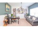 Stylish home office featuring built-in bookshelves, a modern desk, and a comfortable seating area with a gray sofa at 935 Northwich Ave, Westfield, IN 46074