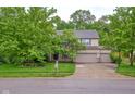 Attractive home exterior with a three-car garage, mature trees, and manicured lawn at 9705 Valley Springs Blvd, Fishers, IN 46037