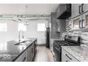 Modern kitchen features gray cabinetry, granite countertops, and stainless steel appliances at 1001 Harlan St, Indianapolis, IN 46203