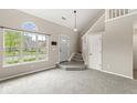 Inviting living room with a large window, a half-moon window above it, stairs to the second floor, and neutral tones at 11072 Lake Run Dr, Fishers, IN 46038