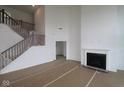 Open-concept living room with fireplace, adjacent to the staircase at 12403 Fresh Stock Dr, Noblesville, IN 46060