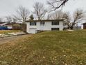 Charming two-story white home with an attached garage and a well-maintained front yard on a cloudy day at 1325 Northcrest Dr, Anderson, IN 46012