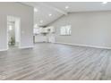 Bright living room with vaulted ceilings, light gray walls, and laminate flooring leading to a well-lit kitchen at 1325 Northcrest Dr, Anderson, IN 46012