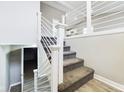 Modern staircase featuring white railings, carpeted steps, and contemporary design elements on a neutral color palette at 1325 Northcrest Dr, Anderson, IN 46012