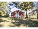 View of the large red outbuilding or barn with a white door on the property's grounds at 13518 Promise Rd, Fishers, IN 46038