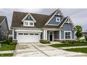 Charming home featuring blue siding, a brown roof, a white garage door and beautifully landscaped front yard at 15596 Edenvale Dr, Westfield, IN 46074