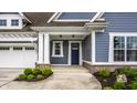 Inviting front entrance with a blue door, white columns, and a well-manicured garden bed at 15596 Edenvale Dr, Westfield, IN 46074