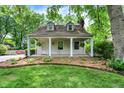 Charming home with a covered porch, complemented by attractive landscaping and mature trees at 1725 W 53Rd St, Indianapolis, IN 46228