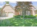 Charming brick home featuring a well-manicured lawn and a convenient two-car garage at 1858 Broadleaf Ct, Greenwood, IN 46143