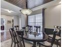 Elegant dining room featuring a coffered wood ceiling, stylish lighting, and a large window at 187 N Bend Dr, Greenwood, IN 46142