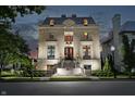 Elegant stone home with meticulous landscaping and a grand entrance at twilight at 1894 Rhettsbury St, Carmel, IN 46032