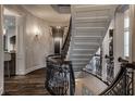 Elegant curved staircase featuring wrought iron railings and hardwood floors at 1894 Rhettsbury St, Carmel, IN 46032