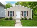 Attractive tan single-story home with dark shutters and walkway at 2402 Adams St, Indianapolis, IN 46218