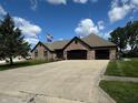 Beautiful brick home with well-manicured lawn, three-car garage, and ample parking space in the driveway at 28 Patriot Ct, Greenfield, IN 46140