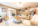 Inviting living room with modern furnishings, a ceiling fan, and an open layout connecting to the kitchen at 2875 Prairie Stream Way, Columbus, IN 47203