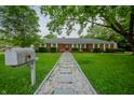 Charming brick home with stone walkway surrounded by lush green grass at 3457 W 58Th St, Indianapolis, IN 46228