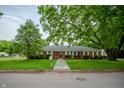 Quaint single-story brick home with a stone pathway and mature shade trees in the front yard at 3457 W 58Th St, Indianapolis, IN 46228