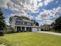 Exterior of two-story home featuring a large lawn, brick facade, and three-car garage at 425 Bridgewater S Ln, Muncie, IN 47304