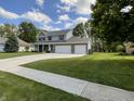 Exterior of two-story home featuring a large lawn, brick facade, and a concrete driveway at 425 Bridgewater S Ln, Muncie, IN 47304
