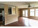 Bright living room featuring wood floors, a ceiling fan, and natural light from large windows and a sliding glass door at 4456 Redcliff N Ln, Plainfield, IN 46168
