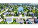 Scenic aerial view of a suburban neighborhood with a tranquil pond surrounded by lush greenery and well-maintained homes at 4506 Tarragon Dr, Indianapolis, IN 46237