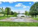 Outdoor basketball court with a water view, bordered by lush greenery and partially enclosed by a chain-link fence at 4506 Tarragon Dr, Indianapolis, IN 46237