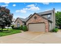 Side view of a well maintained house with a brick facade and an attached two car garage at 4506 Tarragon Dr, Indianapolis, IN 46237