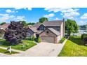 Charming two-story home with a brick facade, attached garage, landscaped yard, and proximity to a serene lake at 4506 Tarragon Dr, Indianapolis, IN 46237