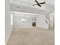 Spacious open-concept living room featuring a high ceiling, a chandelier, and neutral carpet at 4506 Tarragon Dr, Indianapolis, IN 46237