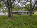 Charming single-story home with a detached garage and a beautiful, spacious front yard featuring mature trees at 5160 N High School Rd, Indianapolis, IN 46254