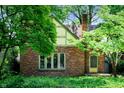 Beautiful brick house featuring a gable roof and a well-maintained yard with mature trees at 521 Kessler Blvd E Dr, Indianapolis, IN 46220