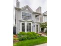Charming two-story home with gray siding, bay window, front porch, and professionally landscaped yard at 626 N Senate Ave, Indianapolis, IN 46202