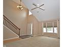Bright living room boasts high ceilings, staircase, neutral tones, and large windows at 6549 Wilshire Pl, Zionsville, IN 46077
