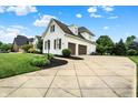 Long concrete driveway leading to a two-car garage and beautifully landscaped yard at 6672 Braemar S Ave, Noblesville, IN 46062