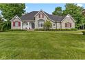 Charming stone home with red shutters, a manicured lawn, and a welcoming front porch at 7016 Royal Oakland Way, Indianapolis, IN 46236