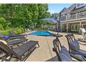 Relaxing pool area with lounge chairs, an umbrella, and lush landscaping at 7016 Royal Oakland Way, Indianapolis, IN 46236