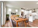 Dining room with wood table and seating, leading into the kitchen with white cabinetry and stainless steel appliances at 7248 Covington St, Lebanon, IN 46052
