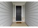 Close-up of the dark wood front door with brick accents and a welcoming 'welcome' mat at 7248 Covington St, Lebanon, IN 46052