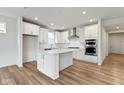 Modern kitchen with white cabinets, stainless steel appliances, center island, and hardwood flooring at 7248 Covington St, Lebanon, IN 46052