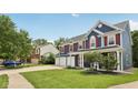 Well-maintained home features lush lawn, three-car garage, and a welcoming front porch at 8241 Holmard Pl, Indianapolis, IN 46259
