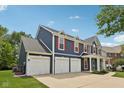 Attractive home boasts a three-car garage, front porch, and well-maintained landscaping at 8241 Holmard Pl, Indianapolis, IN 46259