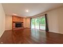 Bright living room featuring hardwood floors and a brick fireplace, a cozy space to unwind at 8772 W Evergreen Dr, Columbus, IN 47201