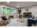 Inviting living room featuring vinyl floors, a fireplace, and a large window with green views at 8905 Washington Blvd West Dr, Indianapolis, IN 46240